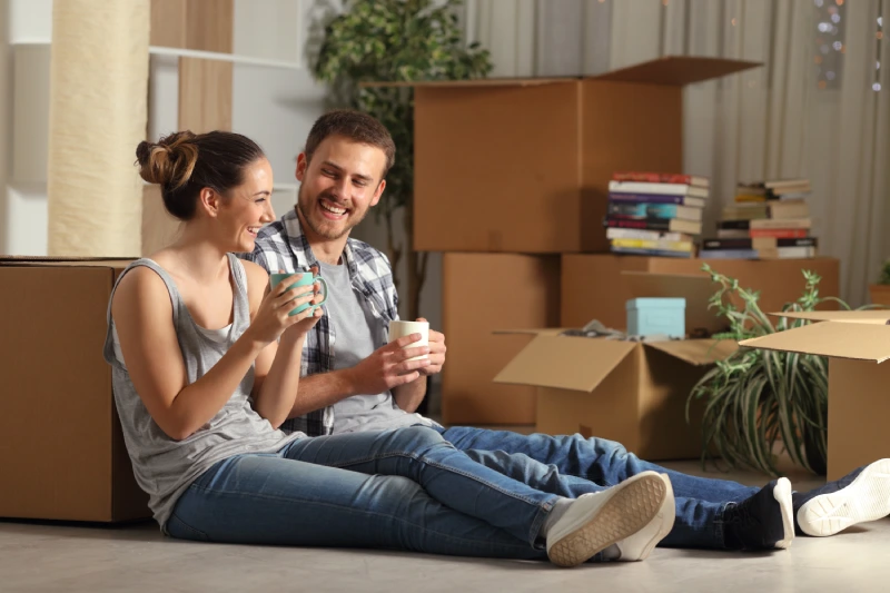 Couple sitting in a newly rented apartment to illustrate the need for renters insurance.